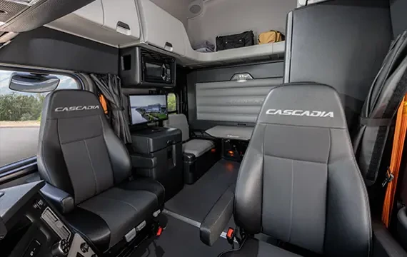 Interior view of a Cascadia Freightliner Bunk with "Cascadia" embossed on the head rest of the chairs.