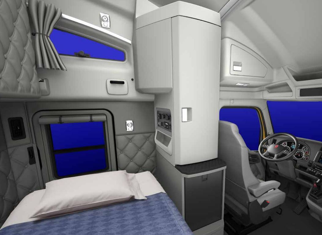 The view inside a bunk of a Kenworth semi truck showing a driver's seat and a bed.